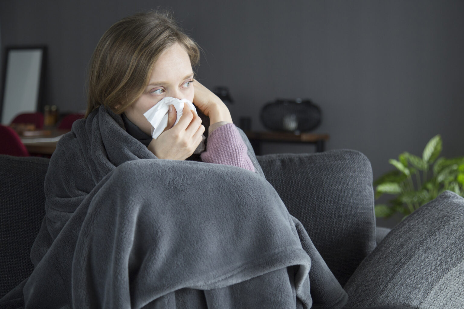 A person with a cold with a tissue